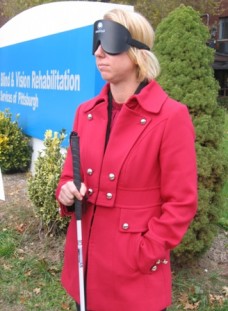 BVRS President Erika Arbogast, under blindfold, learning to use a white cane