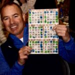 smiling man holding winning bingo card